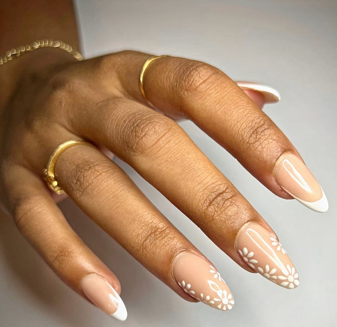 The bride wears a nude and French dip combination with white florals for her wedding manicure from Milano Nail Spa The Heights. 