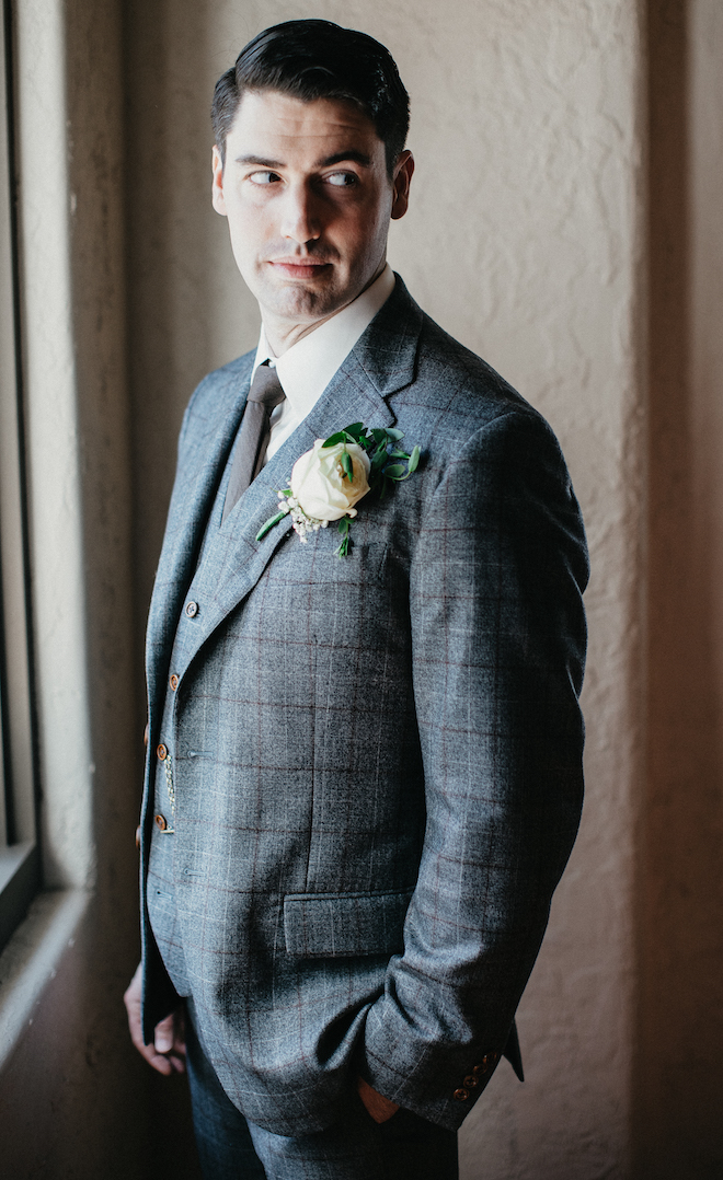 The groom poses in his suit before walking down the aisle.