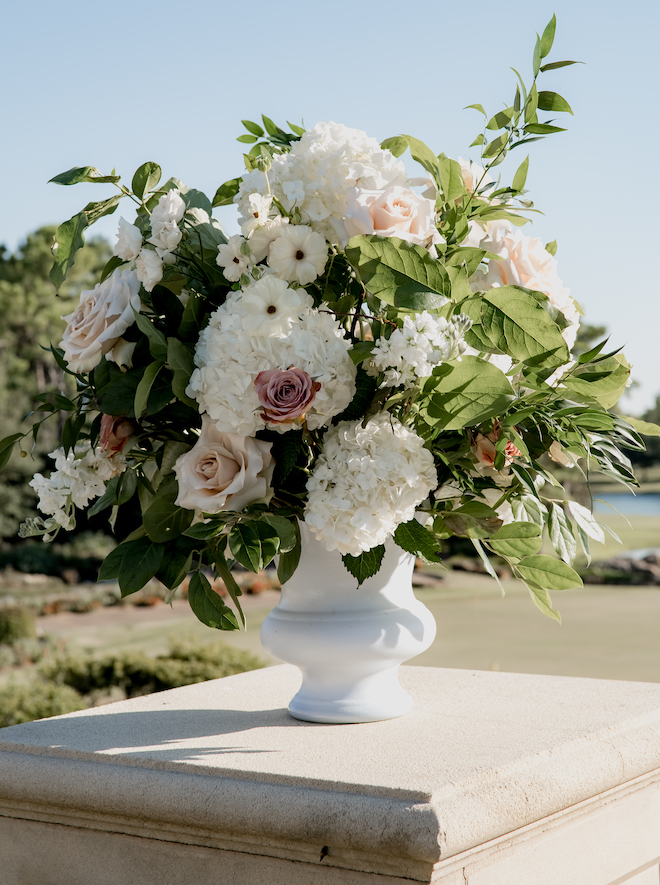 Pink, white and greenery floral arrangements decorate the outdoor wedding ceremony at the Royal Oaks Country Club. 