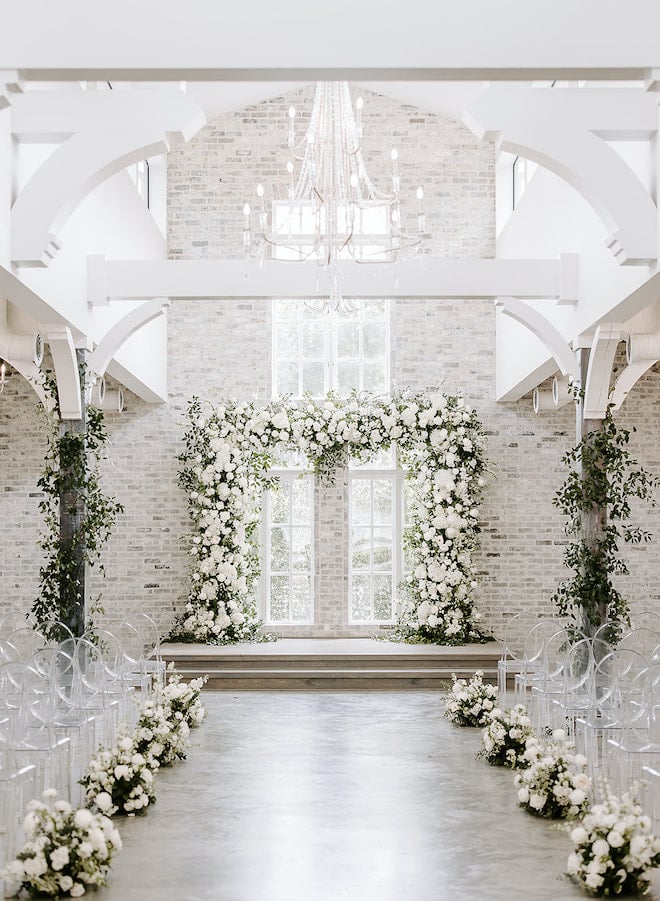 A chapel decorated with white florals and greenery. 