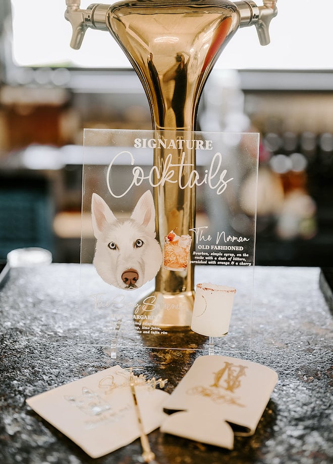An acrylic cocktail menu with a dogs face and two signature cocktails.