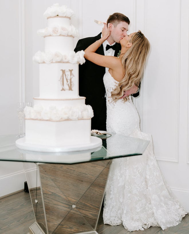 The bride and groom kissing during the cake-cutting. 