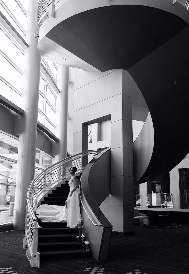 The bride poses on the grand staircase outside of the ballroom at the Royal Sonesta Houston Galleria. 