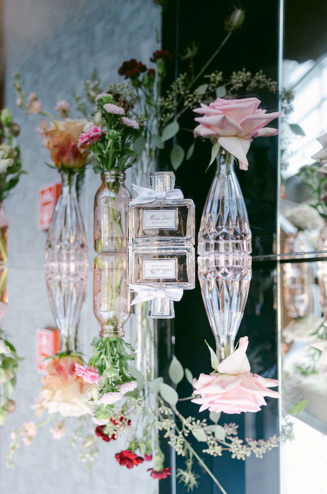 Pastel florals in glass vases and a Miss Dior perfume are placed on a table outside the ballroom at the Royal Sonesta Houston Galleria.