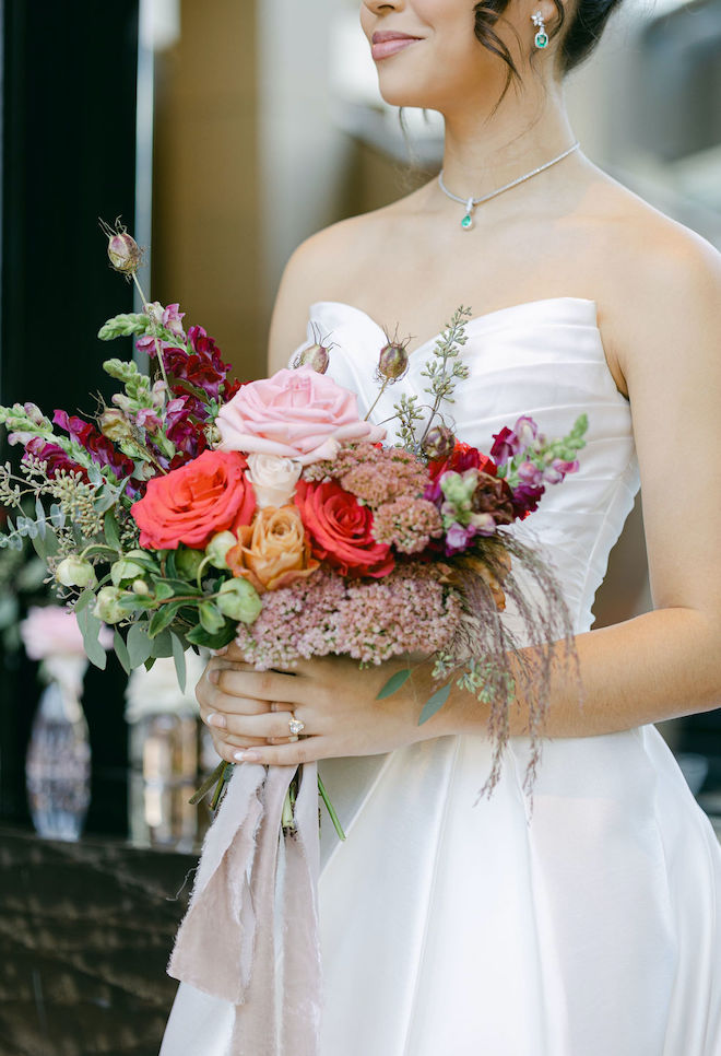 The bride holds her pastel colored wedding bouquet designed by Beyond Bloems for this Houston wedding editorial. 