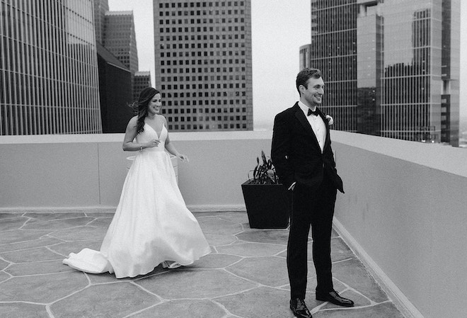 The bride and groom's share their first look at the Magnolia Hotel Houston overlooking the city skyline. 