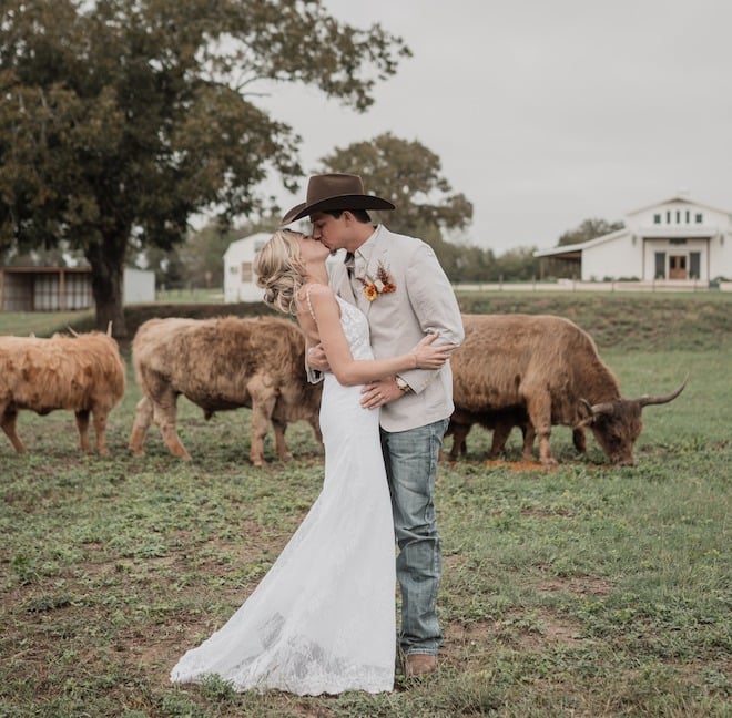 The bride and groom share a kiss in the pasture at Hummingbird Hill for the autumn wedding editorial. 