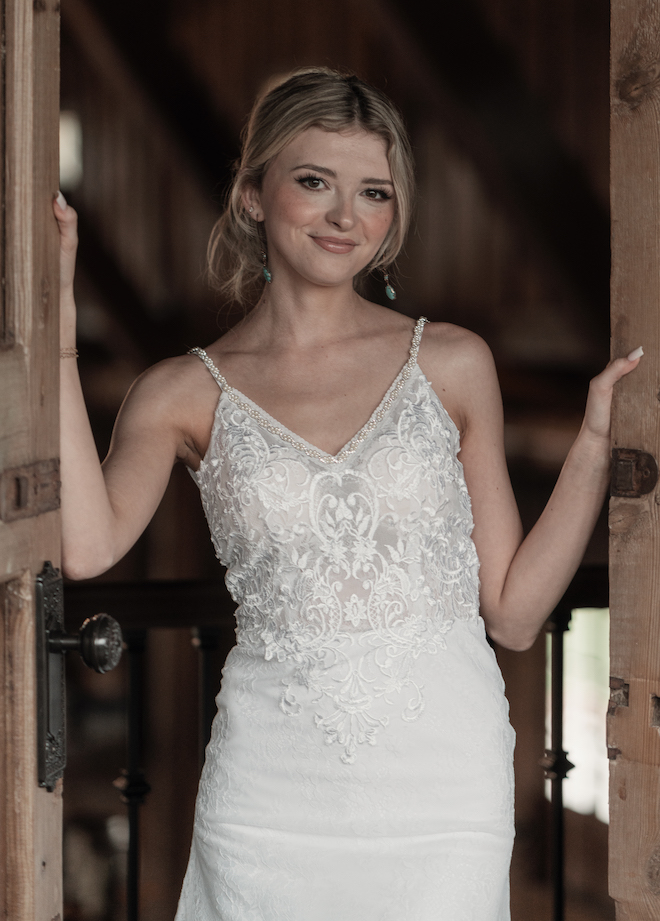 The bride smile while standing in between to wooden doors at the wedding venue, Hummingbird Hill.