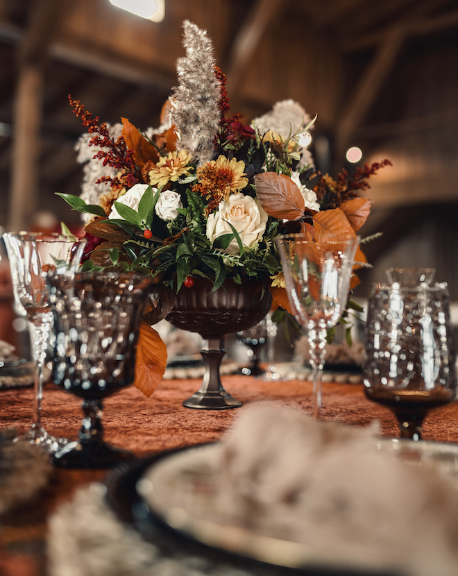Burgundy, orange and white florals and pampas grass detail the floral centerpieces for the wedding editorial. 