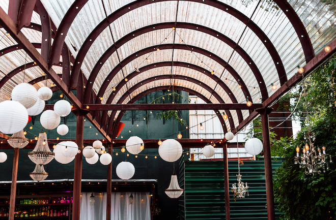 Chandeliers and paper lanterns decorate the reception space for the bohemian wedding.