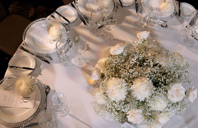 White florals, black and white stationery and candlelight decorate the reception tables. 