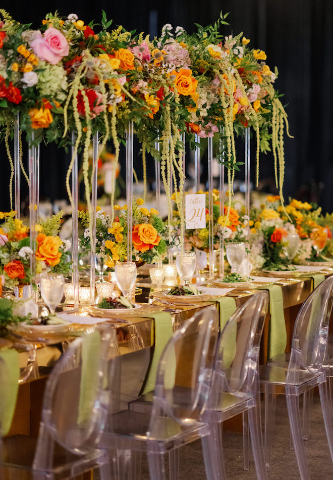 Greenery, orange, yellow and pink table centerpieces. 