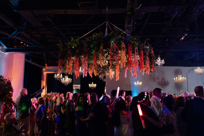 Guests dancing under the large floral installation. 