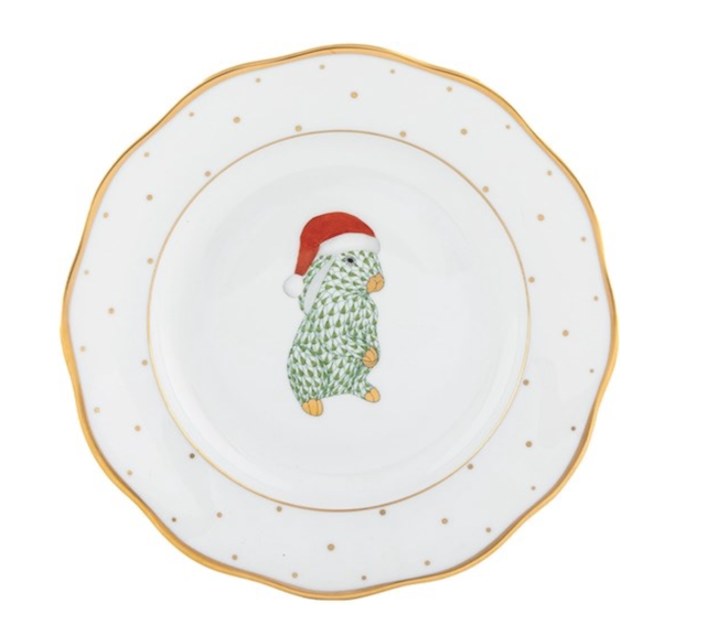 A gold and white polka dot Herend plate with a bunny and Santa hat on. 