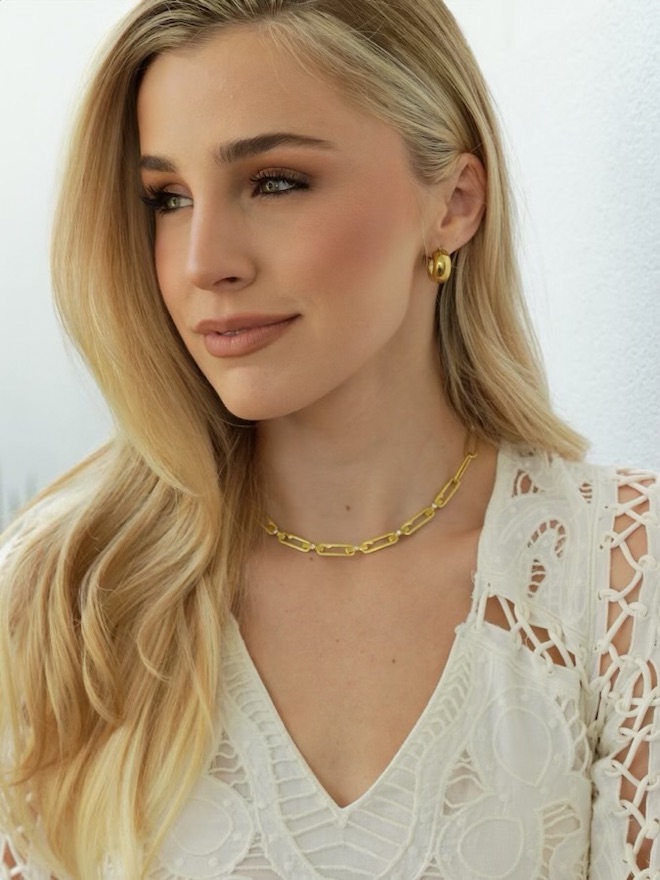 Reagan Bregman wearing a gold necklace and gold earrings from her new collection.