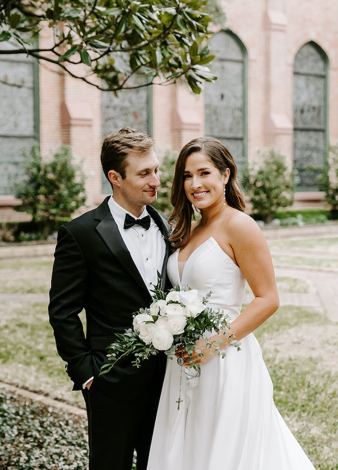 The bride and groom pose outside of a Houston church for their bride and groom portraits. 