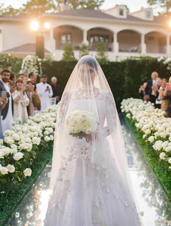 The bride walks down the aisle at her wedding in Houston by The Events Company.
