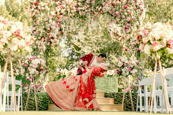 The groom dips his bride and gives her a kiss at their Hindu ceremony at Hyatt Lost Pines Resort and Spa.