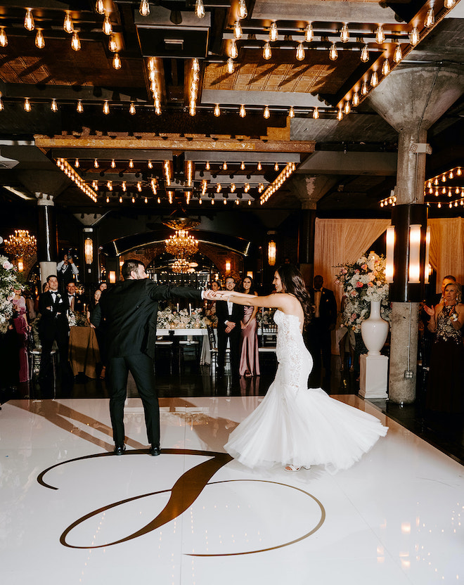 Bride and groom dancing on a monogrammed dance floor during a wedding reception at the Astorian 