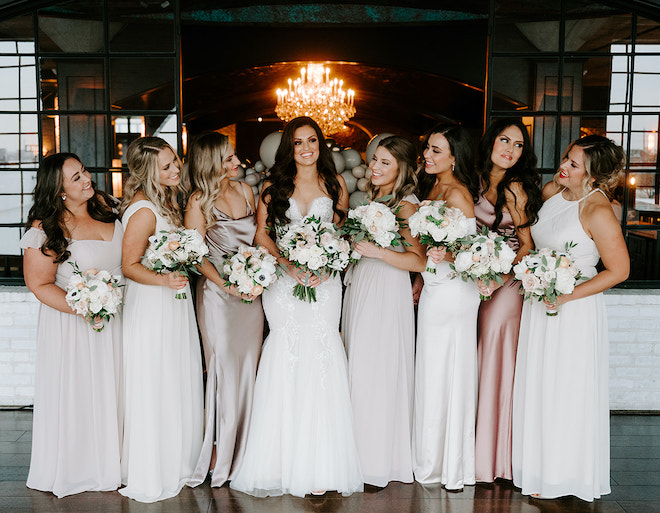The bride and her bridesmaids pose before the wedding ceremony at the Houston wedding venue, The Astorian.