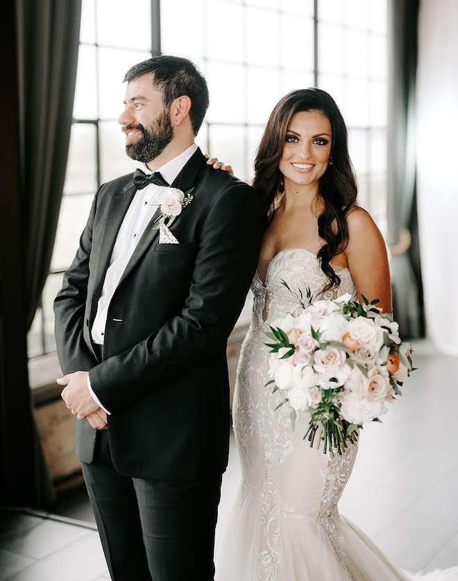 The bride and groom pose for their dusty rose and a white wedding day at the Houston wedding venue, The Astorian. 