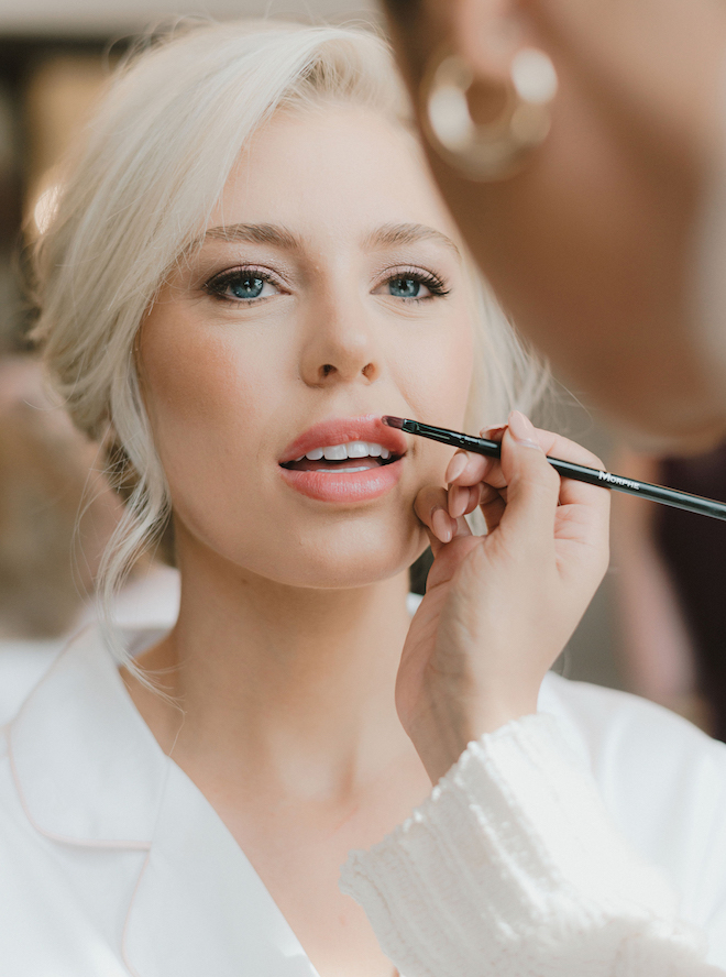 The bride wears a soft, natural glam makeup and hair look for her wedding day. 