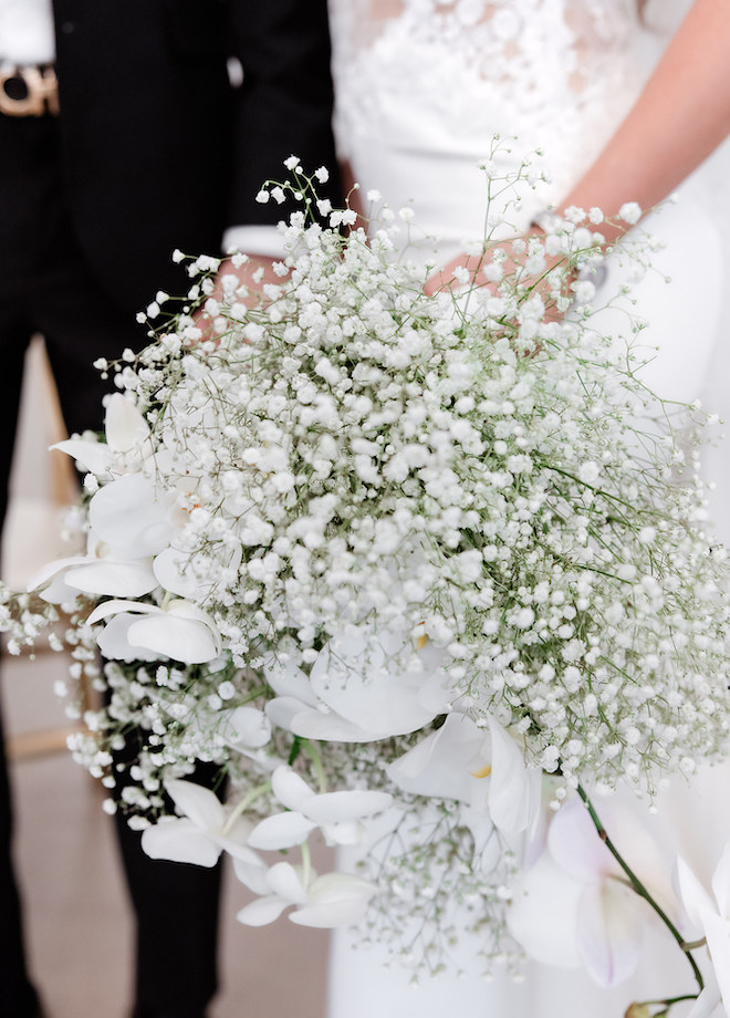 A wedding bouquet of baby's breath and white florals. 