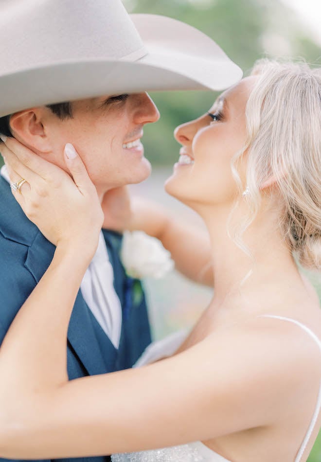 The bride and groom look into each others eyes and smile at their sentimental Texas ranch wedding.