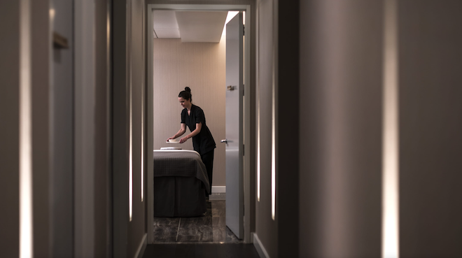 A lady preparing a massage bed.