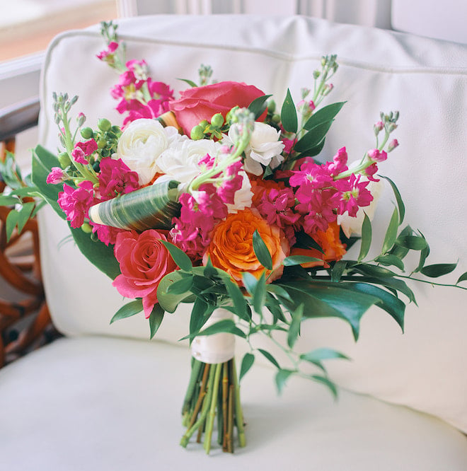 A bouquet of pink, orange and white florals with greenery.