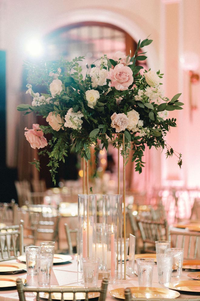 Pink, white and greenery floral centerpieces detail the reception tables. 
