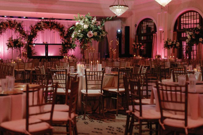 The Houston venue's ballroom is detailed in greenery, pink lighting and floral centerpieces.