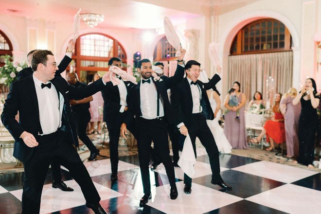 The groom and his groomsmen dance on the dance floor at the ballroom reception.