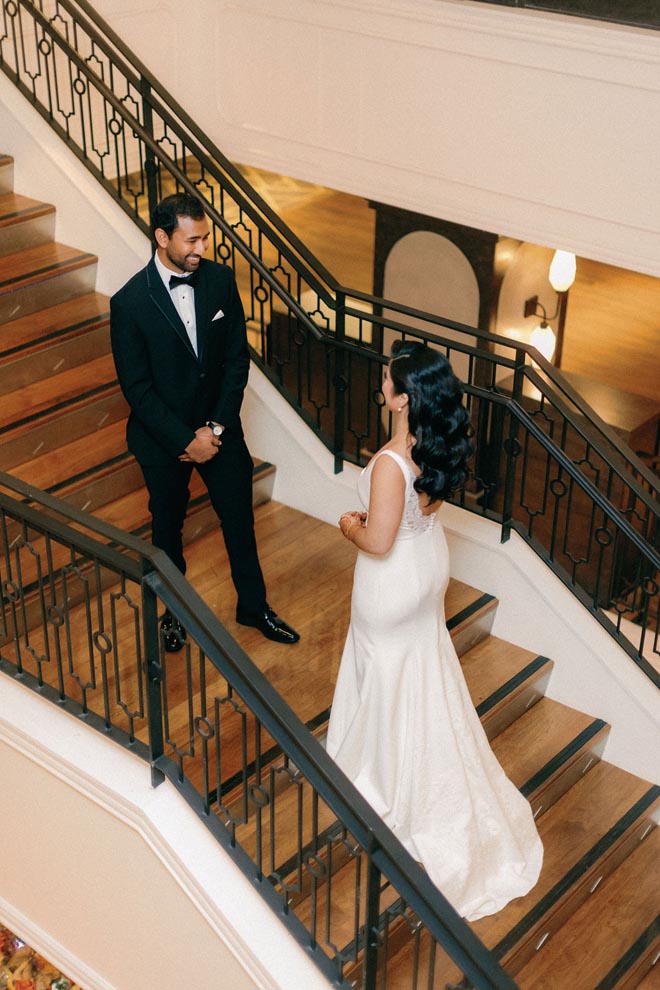 The bride and groom share a private first look on the staircases at the Magnolia Hotel Houston.
