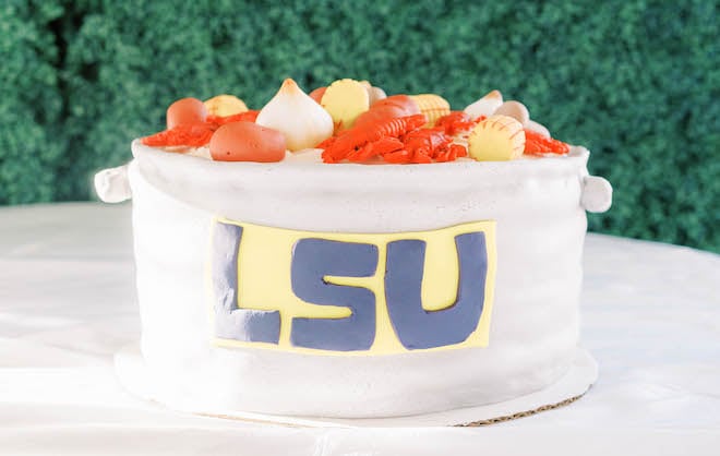 The groom's cake is shaped into a pot decorated with crawfish, potatoes, onions and the LSU logo.