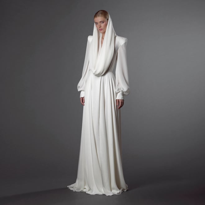 The model wears a designer wedding gown featured in Naeem Khan's Fall 2024 collection.