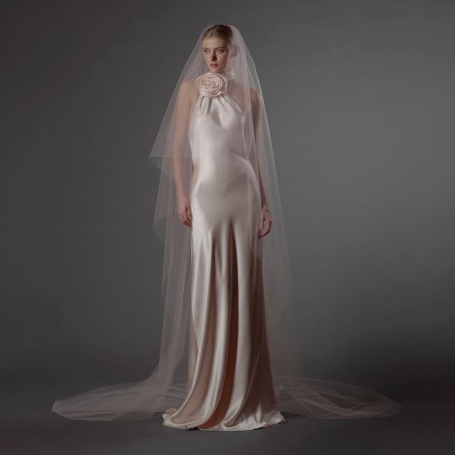 The model wears a rose colored silk wedding gown from Naeem Khan's Fall 2024 Collection.