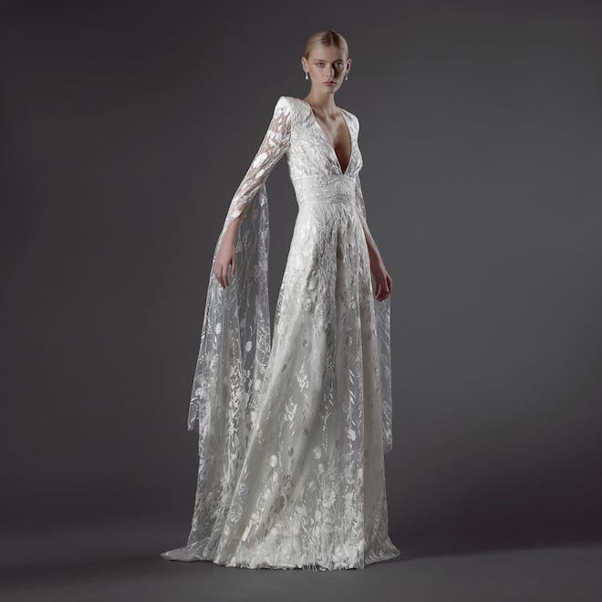 The model wears a sheer wedding gown with dahlia florals designed by Naeem Khan.