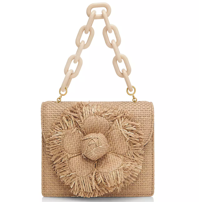 Brown raffia bag with a flower detail and top handle. 