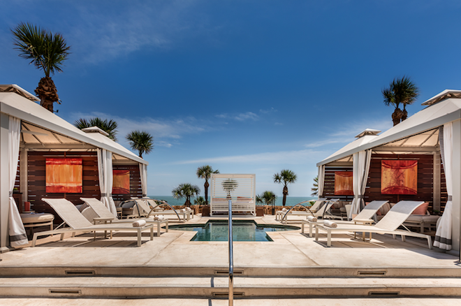 A pool with cabanas looking over the ocean at The San Luis Resort, Spa & Conference Center. 