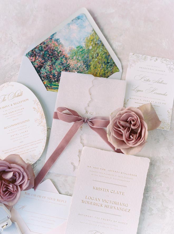 A pink, white and beige invitation suite with a watercolor-style envelope. 