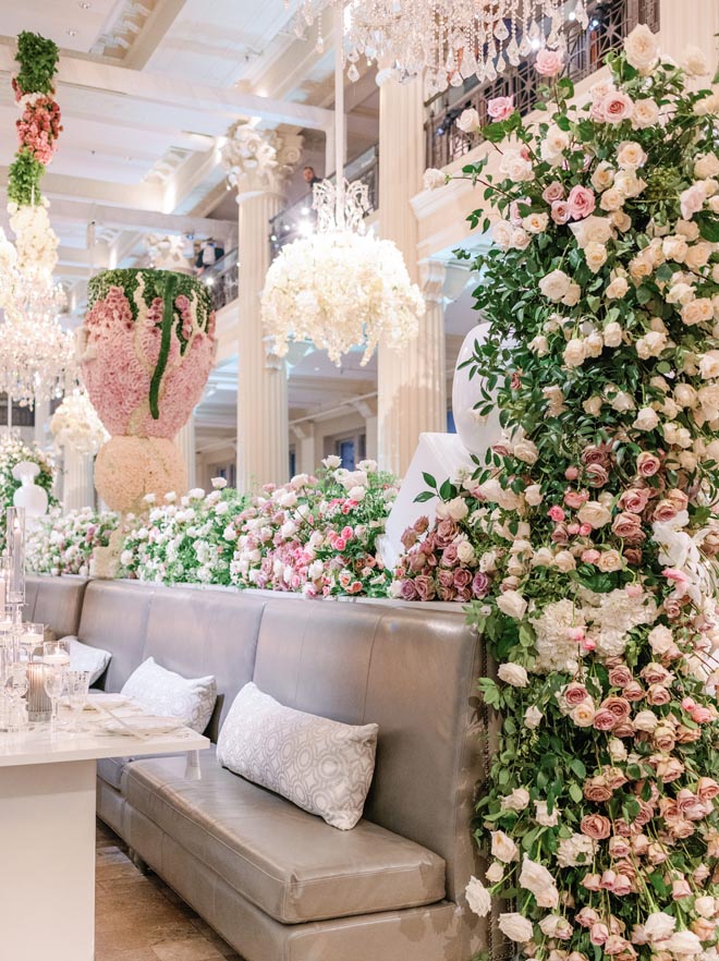 A seating area at the reception with pink white and green floral installations. 