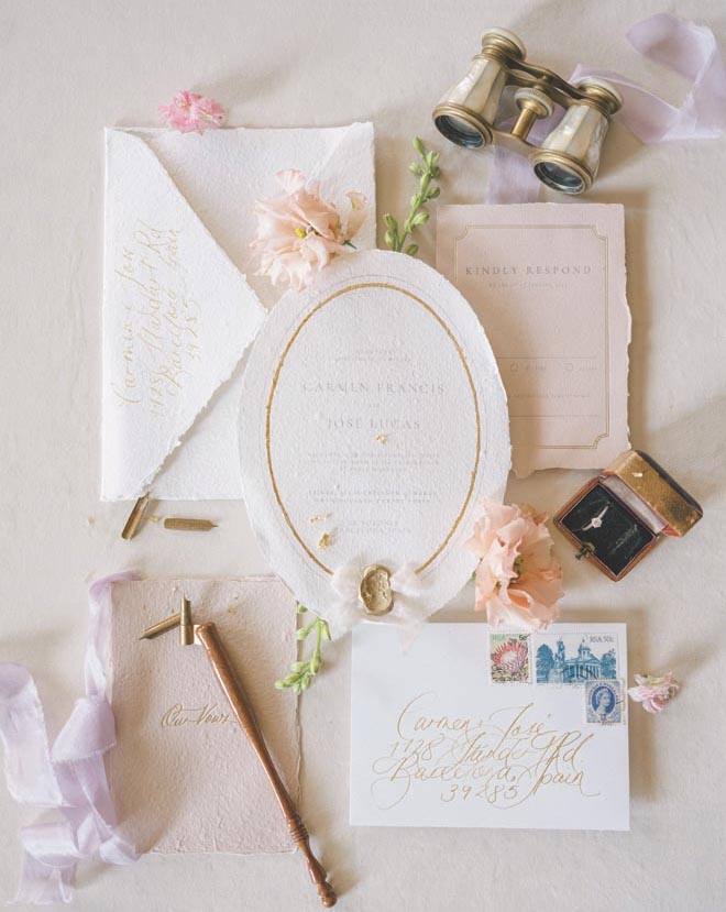 A pink white and gold invitation suite. 