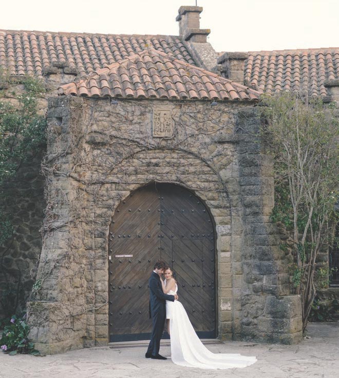 The bride and groom posing in front of La Baronia. 
