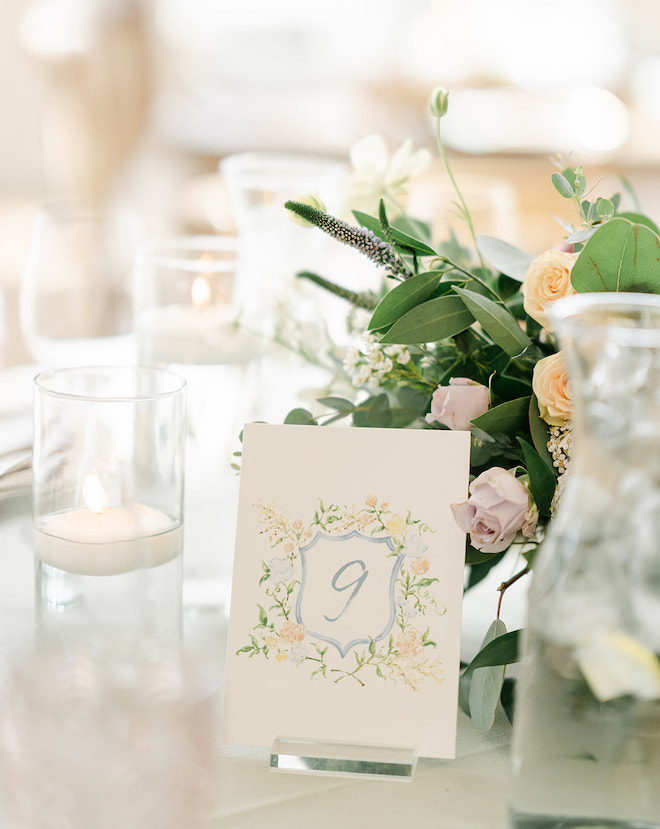 A table number painted in blue with pink and green florals painted around it. 