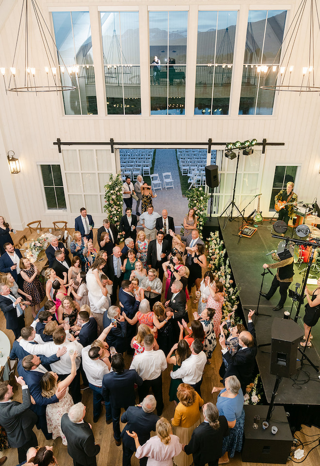 The guests dancing in the reception hall with a view of the mountains in Park City, Utah.