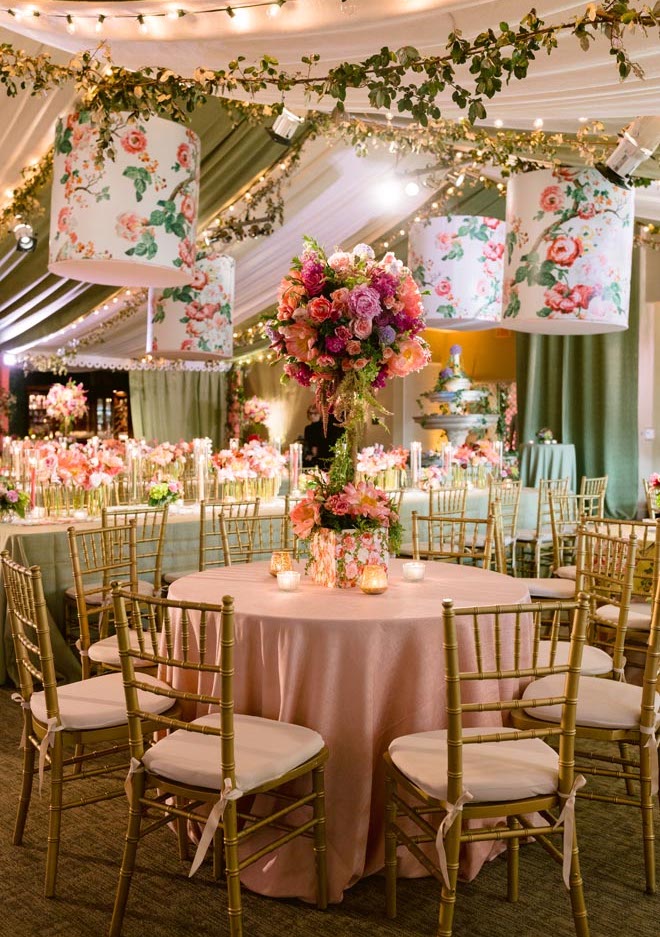 A round reception table with a pink and orange floral centerpiece. 