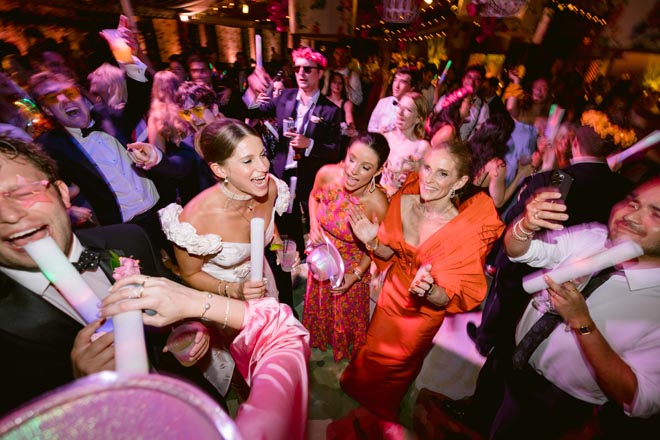 The bride and groom dancing with guests during the reception. 