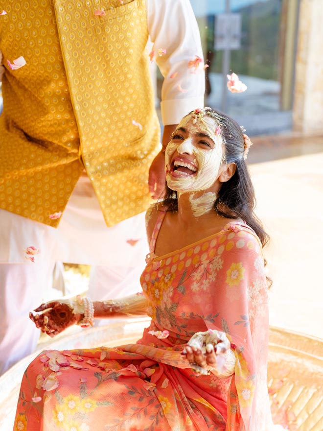 The bride laughs at her haldi ceremony in Malibu.