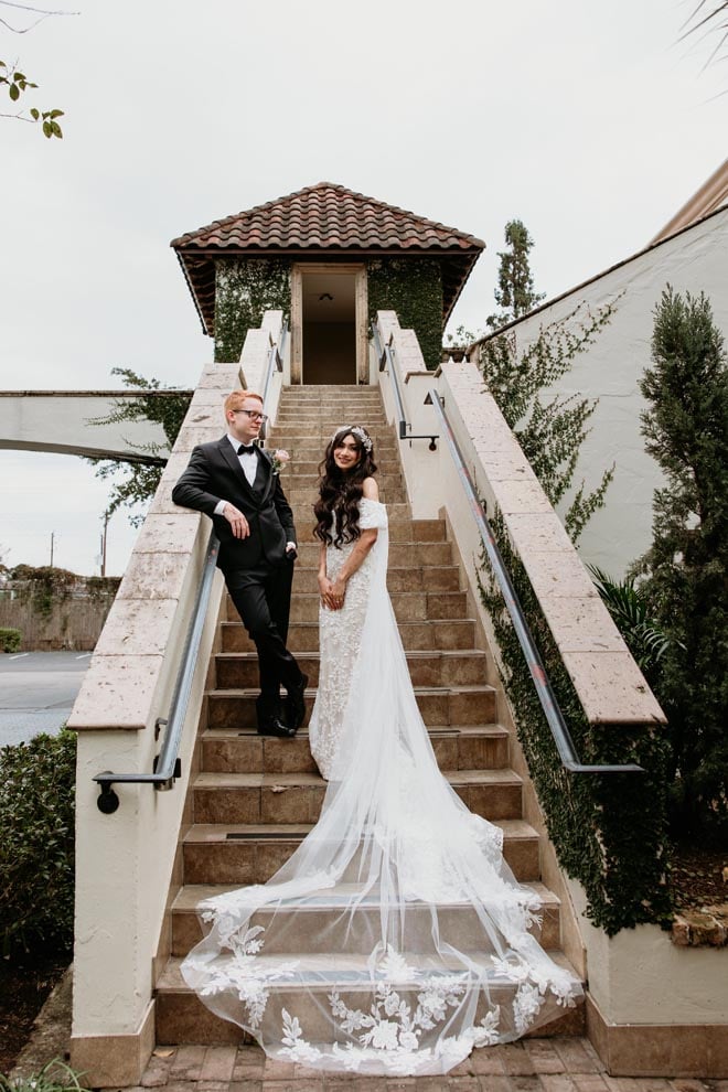 The bride and groom pose on a set of stairs outside The Bell Tower on 34th.